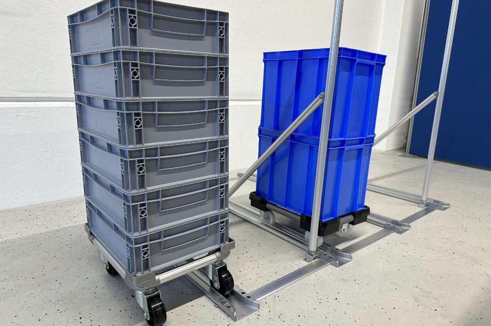 BeeWaTec FIFO Station that displays storage containers on wheeled platforms, positioned on a guided track system for easy movement and organization.